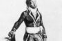 Jean-Jacques Dessalines, est né esclave (1758-1806) à Cornier, Grande-Rivière-du-Nord, dans la partie française de l'île de Saint-Domingue (République d'Haïti) sur la plantation Duclos, où il est devenu commandant (responsable de l'organisation du travail des esclaves); il a ensuite été acheté par un descendant afro libre nommé Dessalines